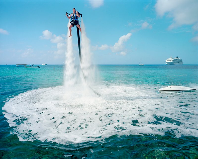 An employee of “Jetpack Cayman” demonstrates this new watersport, now available on the island. Mike Thalasinos, the owner of the company, remarks, “The Jetpack is zero gravity, the Cayman are zero taxes, we are in the right place!” Grand Cayman © Paolo Woods e Gabriele Galimberti